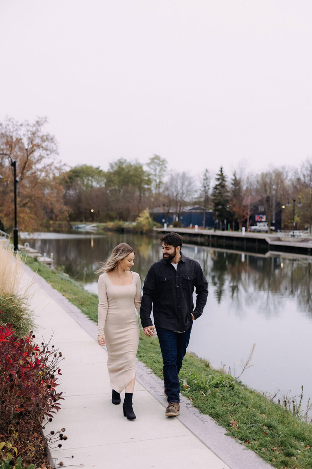 Couple walking along beside the lake for  maternity photos in Finger Lakes New York