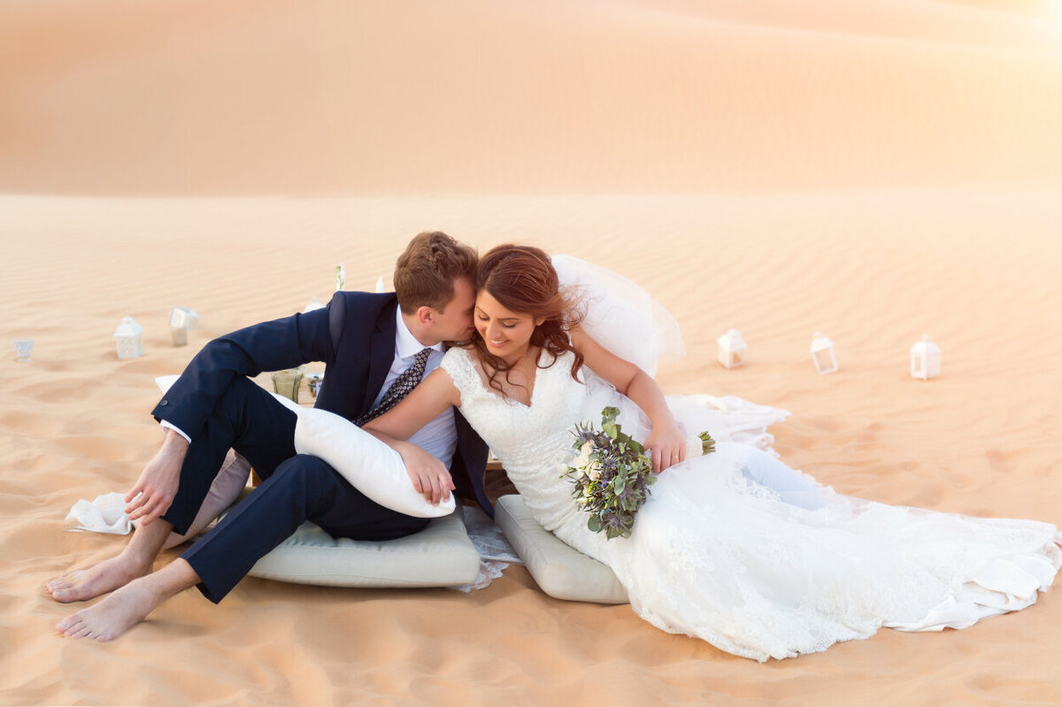 Wedding couple posing in front of sweetheart table during desert elopement photoshoot in Dubai organized by Lovely & Planned