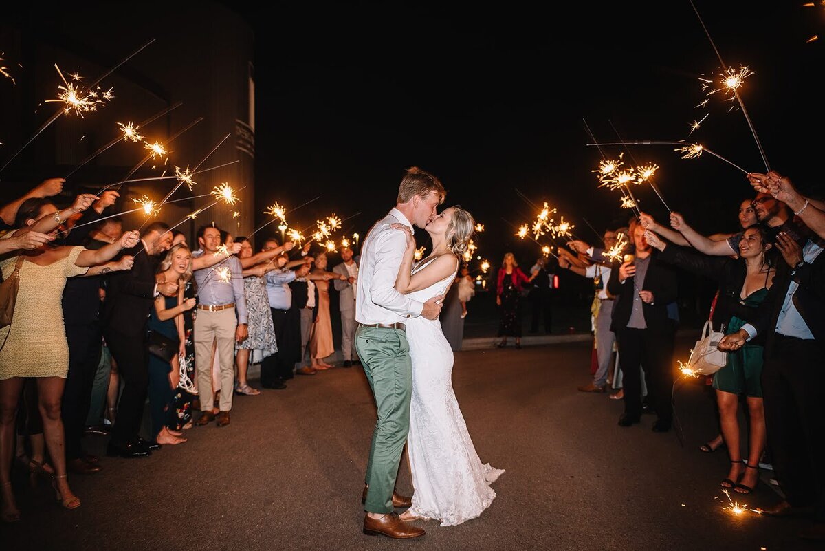 Bride and groom share a kiss during their sparkler grand exit in Colorado.