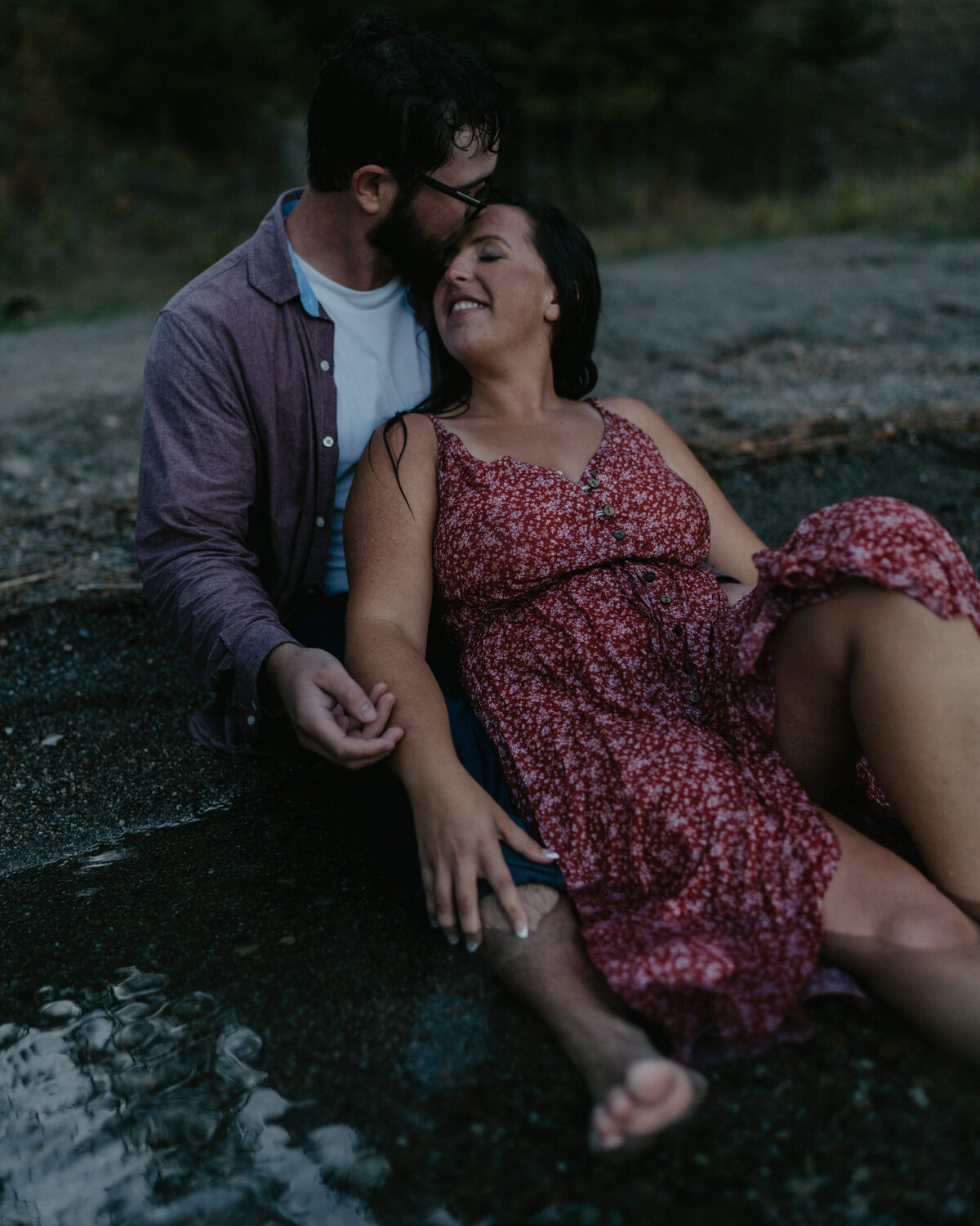 A couple shares a quiet moment by the water during their lakeside engagement session in Washington, capturing serenity and connection.