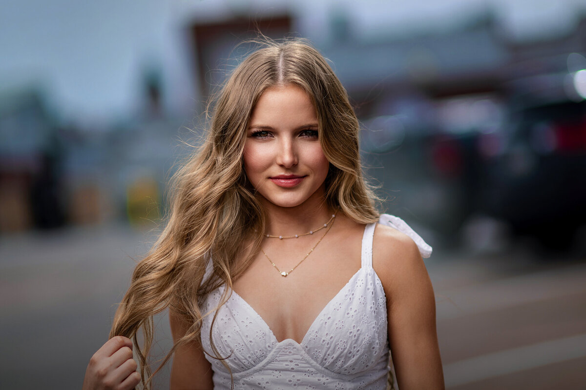 A Pella Senior Photographer twirling her hair in a white dress