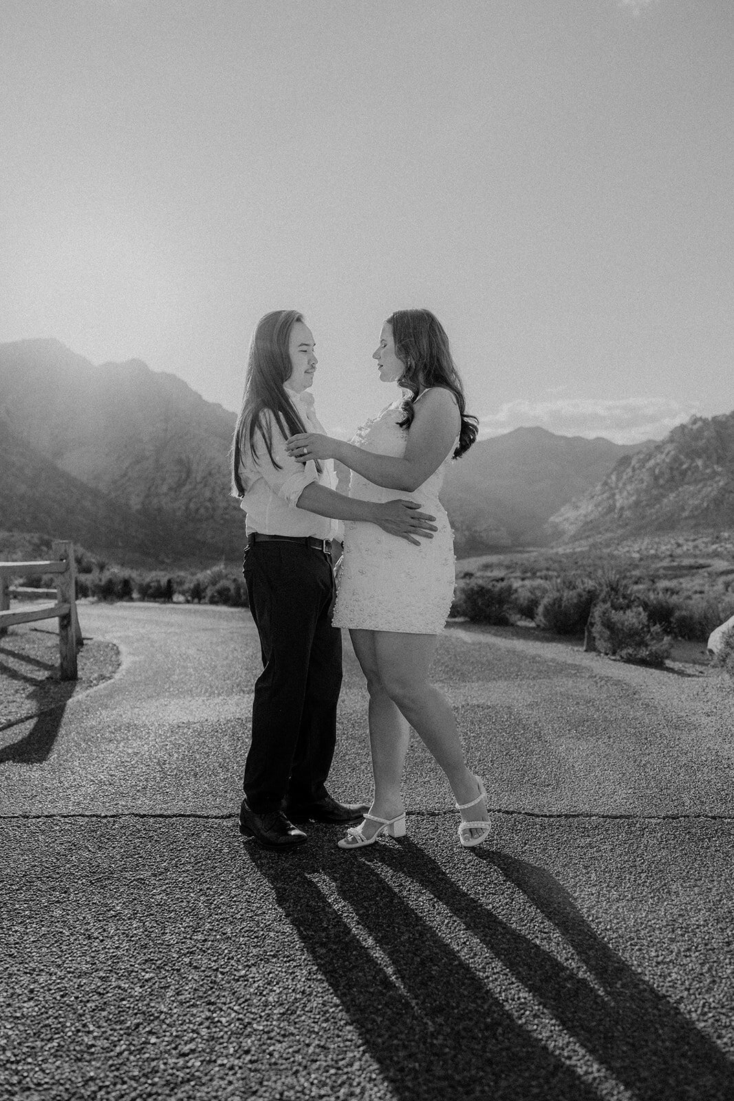 Engaged couple walking on empty road with Nevada mountains in the back