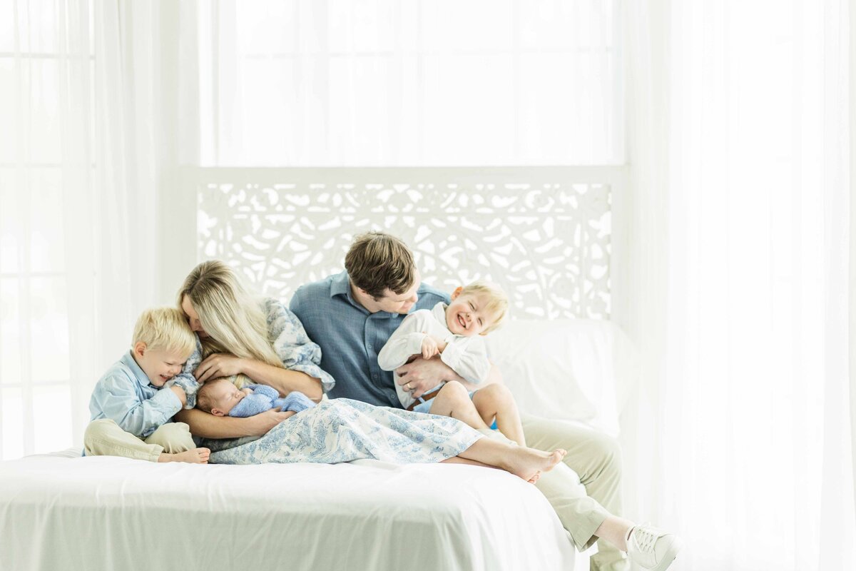 family of five tickle each other for newborn session