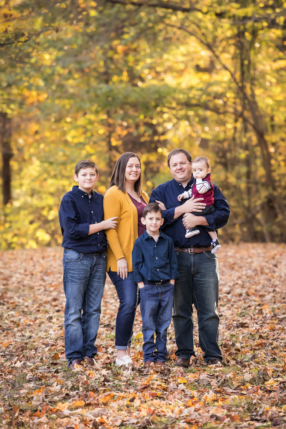 family in fall leaves at park