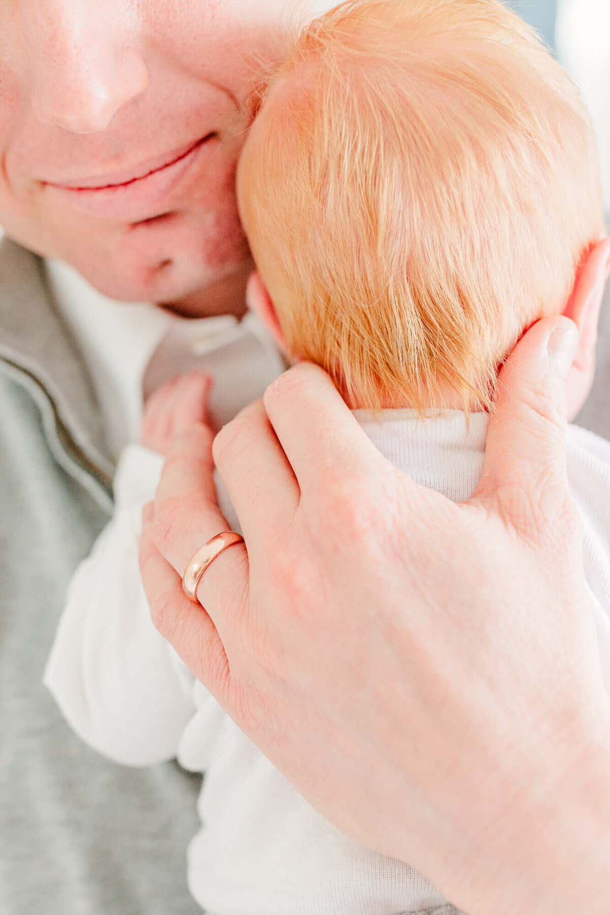 Close up image of dad holding newborn baby close to his chest