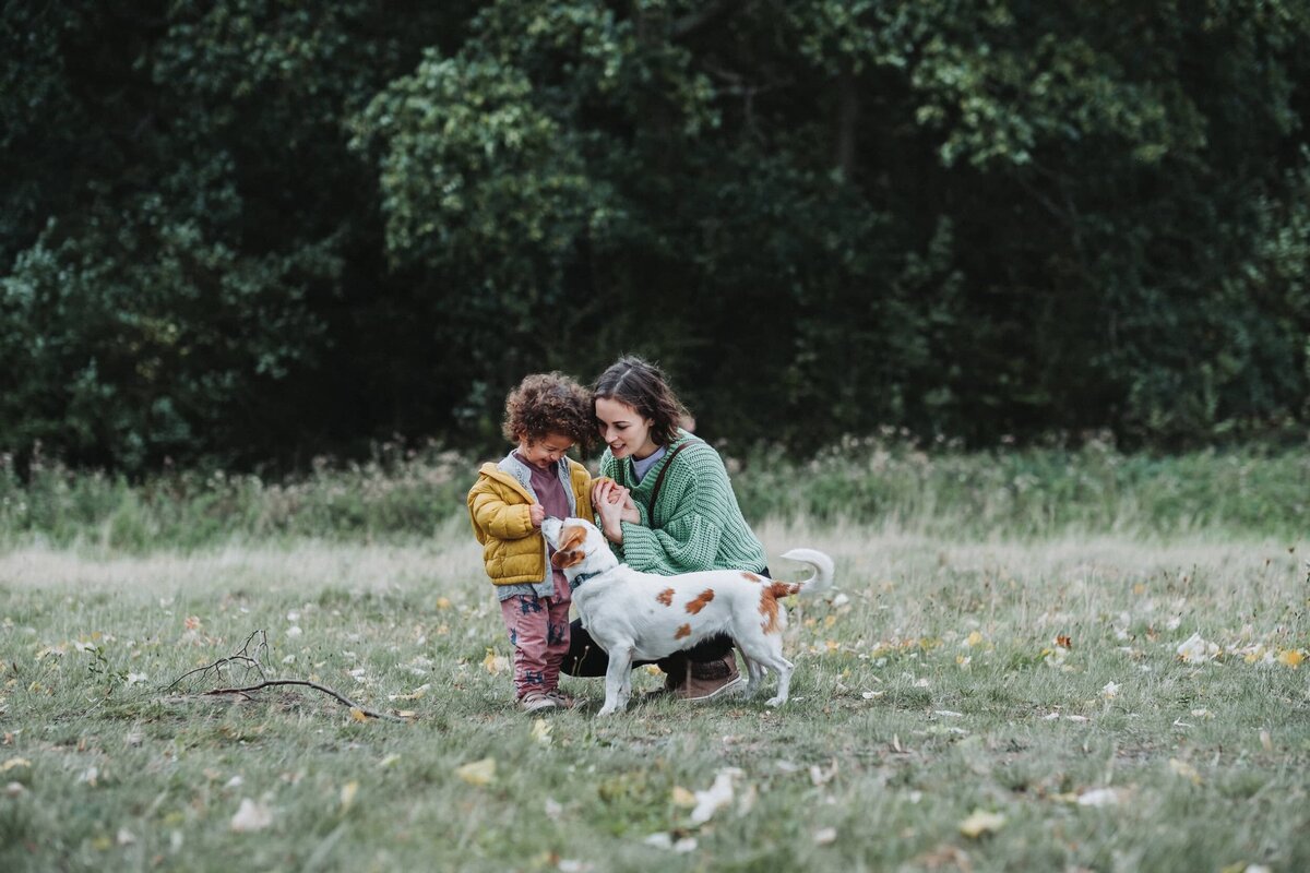 Girl with her mum petting a dog in Hampstead North London