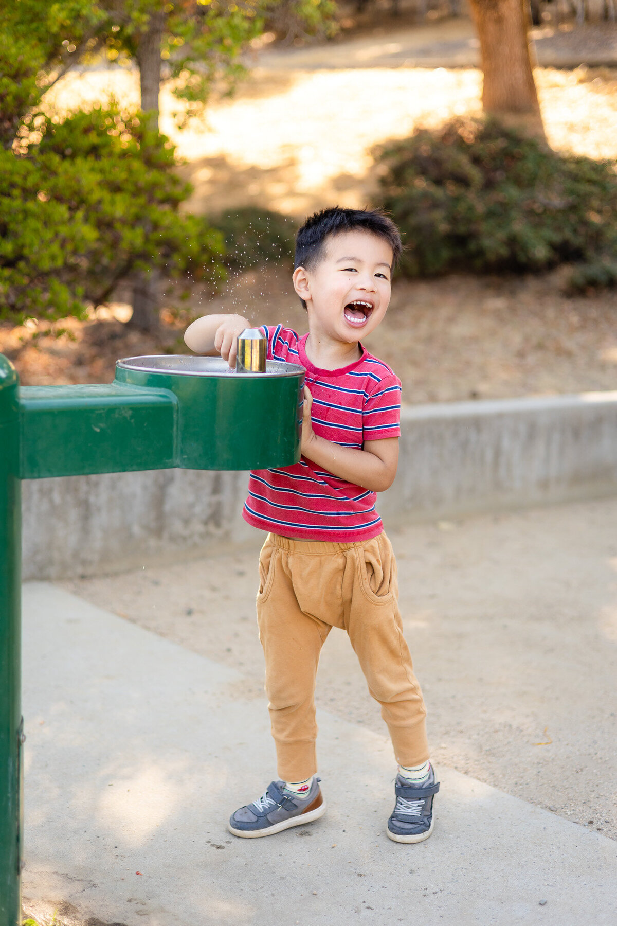 Laughing child playing with water fountain at school playground – Bay Area School Photography Lifestyle – Ellobelle Photography