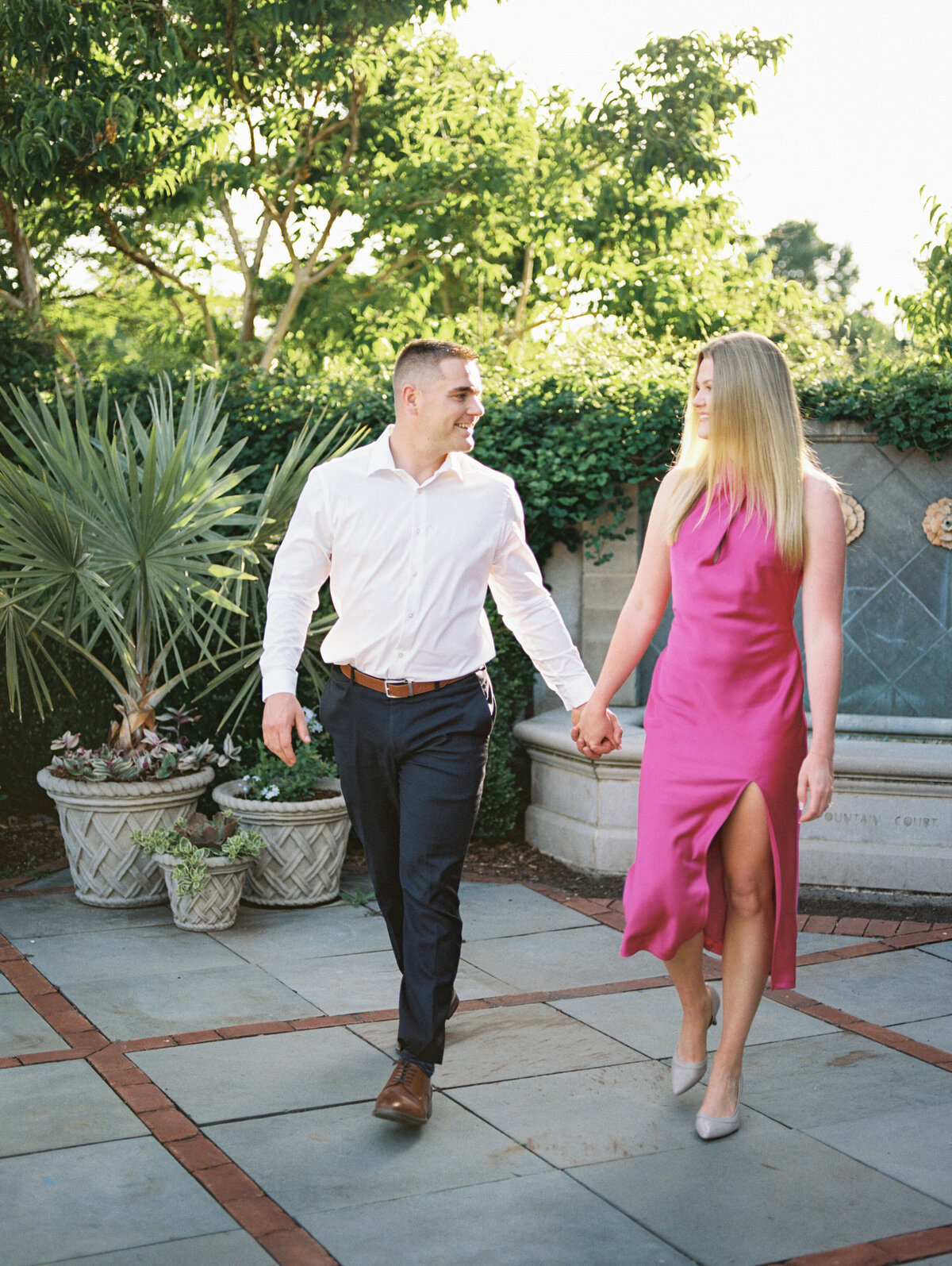 Couple walking away from stone fountain in Columbus park shot by Philadelphia wedding photographer.