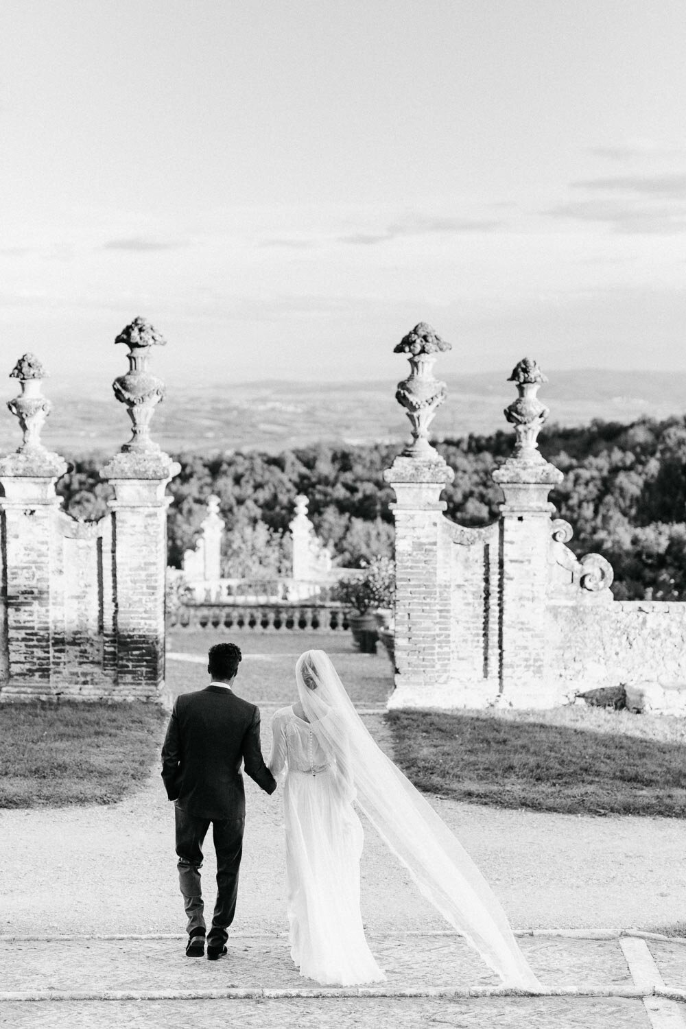 Black and white couple walking away castello di celsa