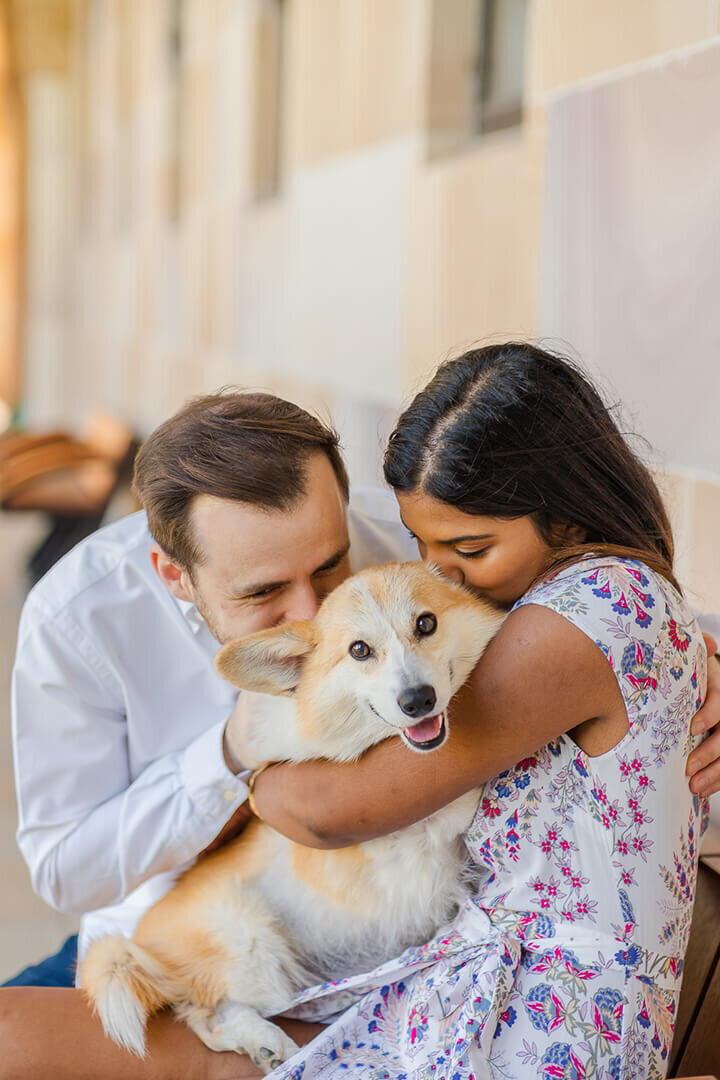 couple hugging pet dog during engagement photoshoot at uq great court brisbane