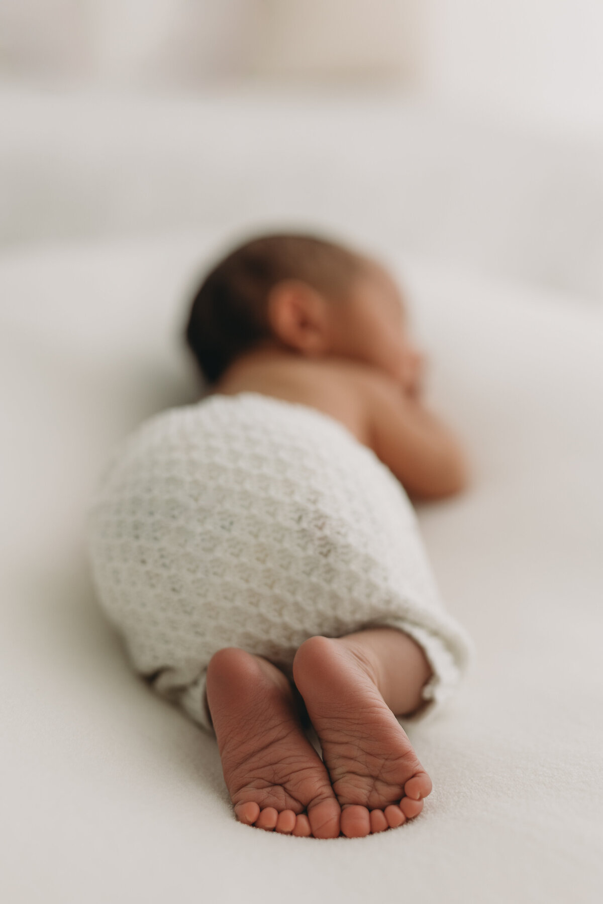 newborn baby feet in all white studio