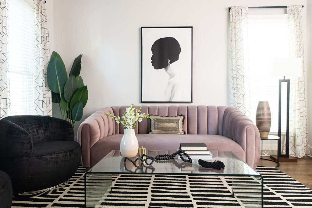 black and white artwork hanging above a lavender couch