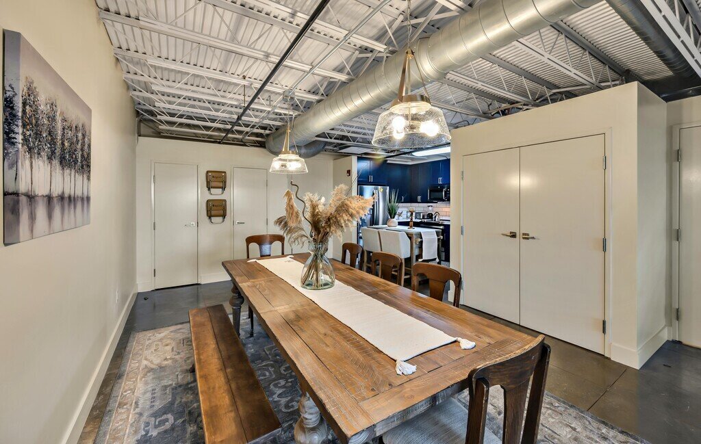Spacious dining room table for eight in this 2 bedroom, 2.5 bathroom luxury vacation rental loft condo for 8 guests with incredible downtown views, free parking, free wifi and professional decor in downtown Waco, TX.