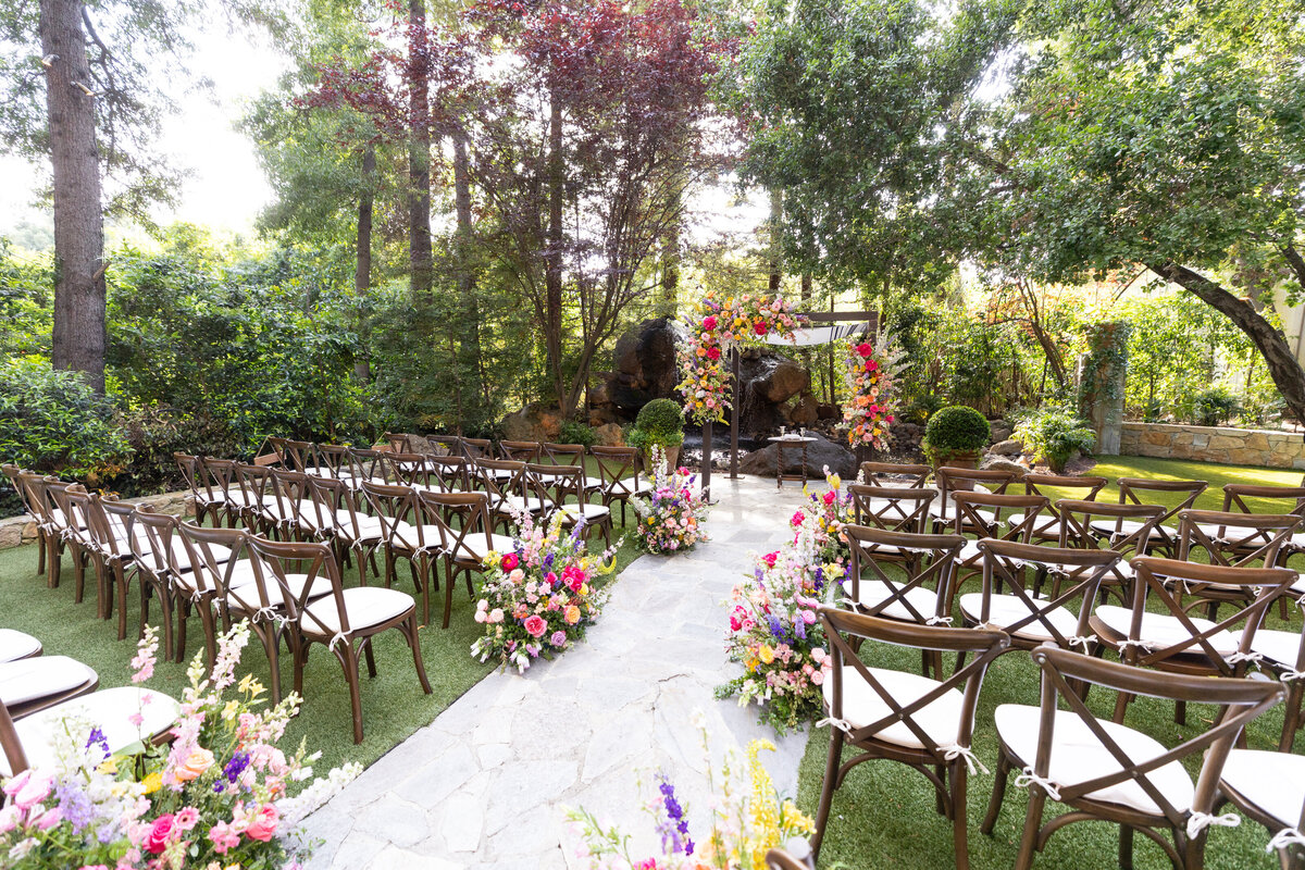 A wedding ceremony site with flowers lining the aisle