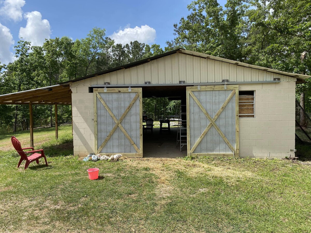 white-barn-with-open-sliding-wooden-doors