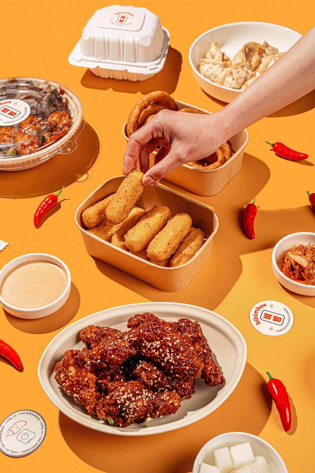 Mozzarella sticks product photography featuring a hand grabbing a stick in Columbia, SC on a yellow backdrop