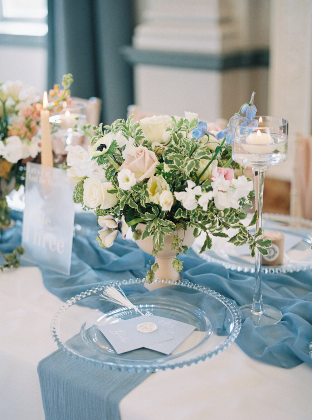 wedding table setting with blue and blush wedding flower arrangement