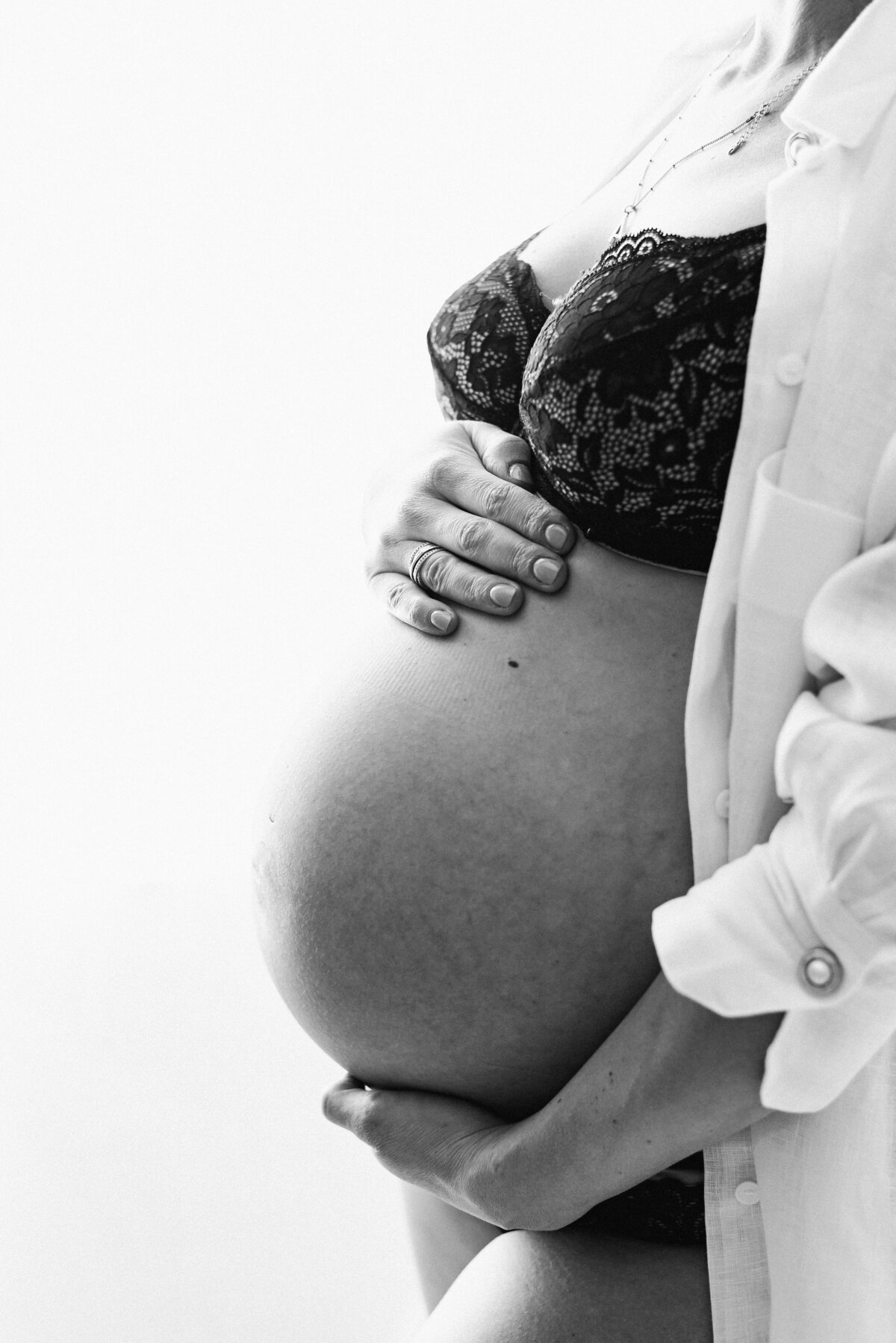 A pregnant mother holding her belly at maternity photoshoot in billingshurst