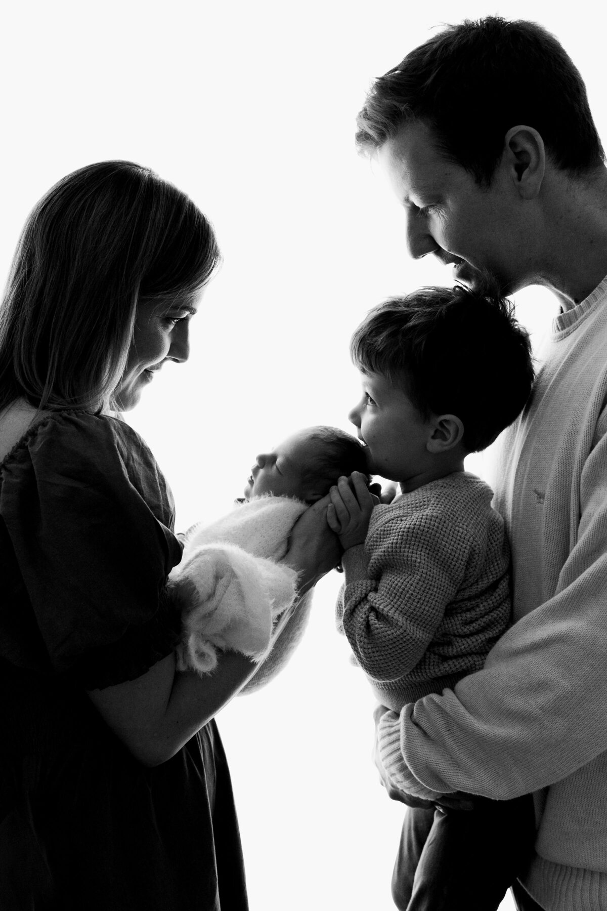 Black and white of family holding newborn baby