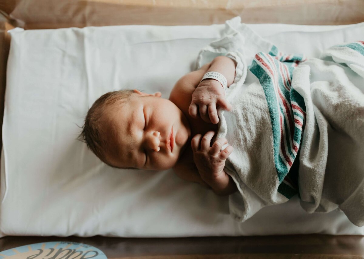 Capture the serenity of a newborn as they peacefully rest on a hospital bed with the skilled eye of a Pittsburgh newborn photographer.