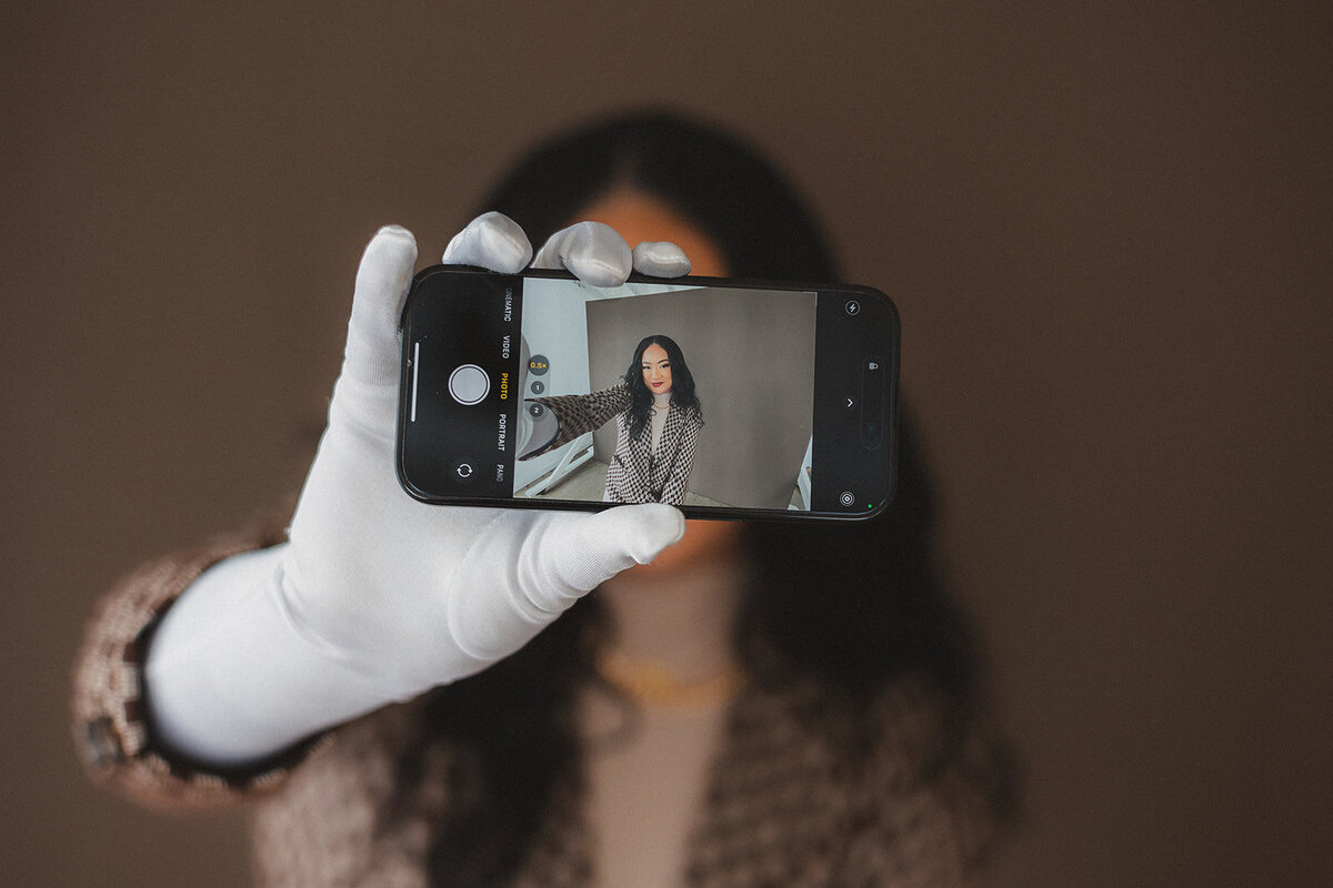 A woman takes a selfie with the phone pointed towards the viewer