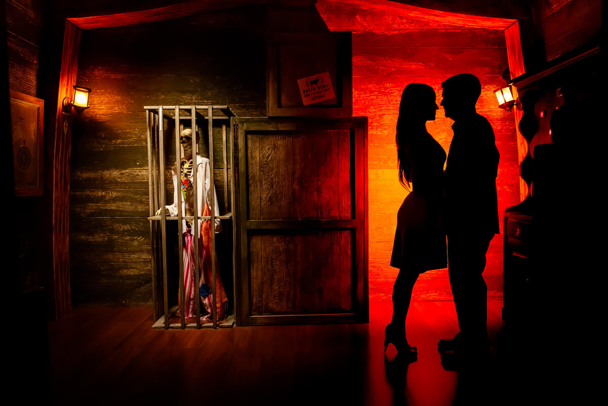 Silhouette of a couple facing each other in a dark room with a red glow