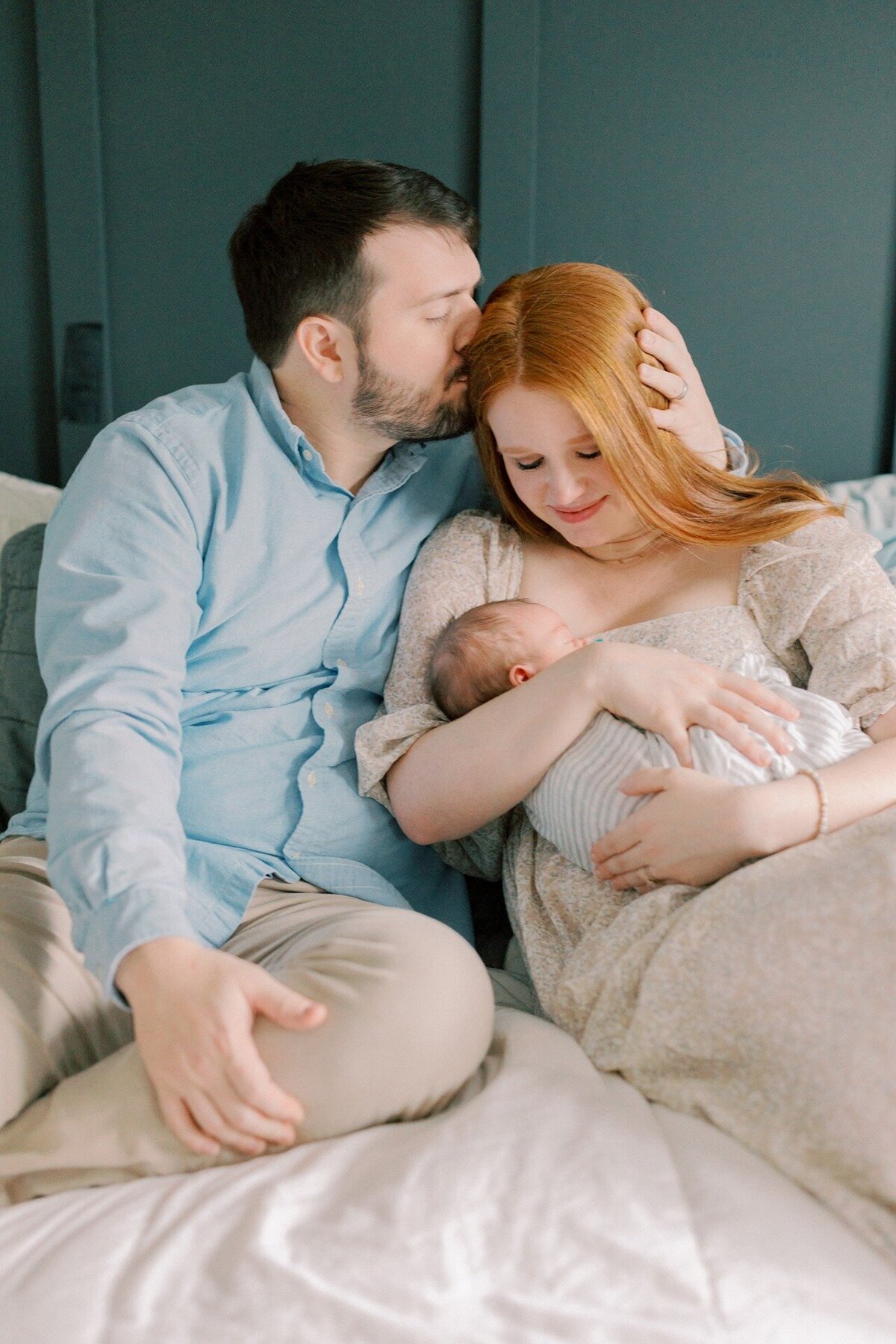 dad-kissing-moms-head-as-she-admires-newborn