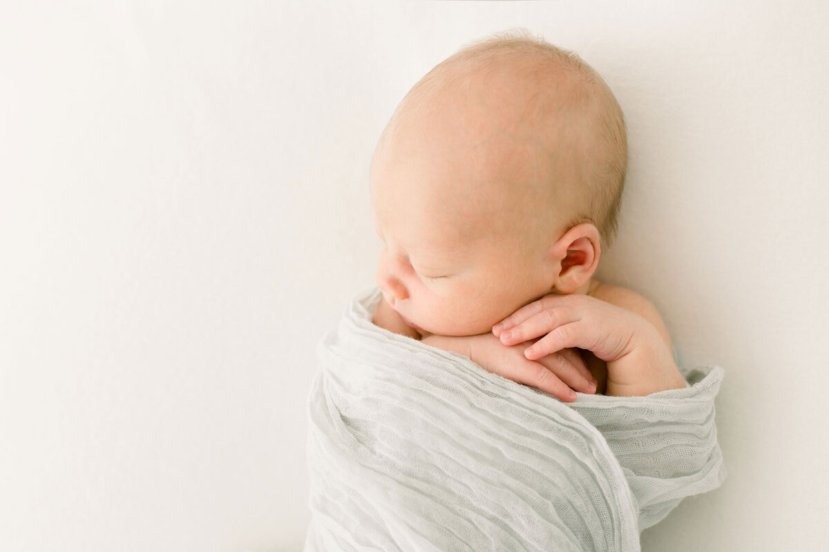 Babyshooting: Neugeborenes in einem pastellfarbenen Tuch