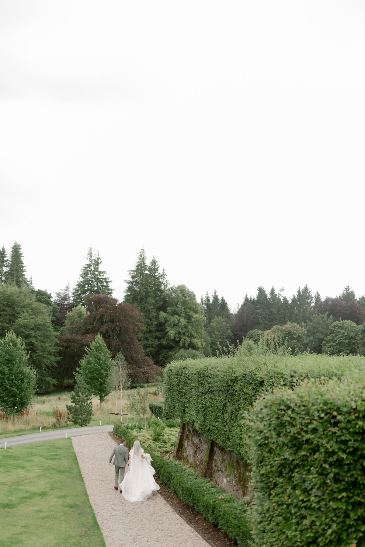 Bride and Groom walking in the grounds of Cromlix House, photographed by Scotland fine art wedding photographer.
