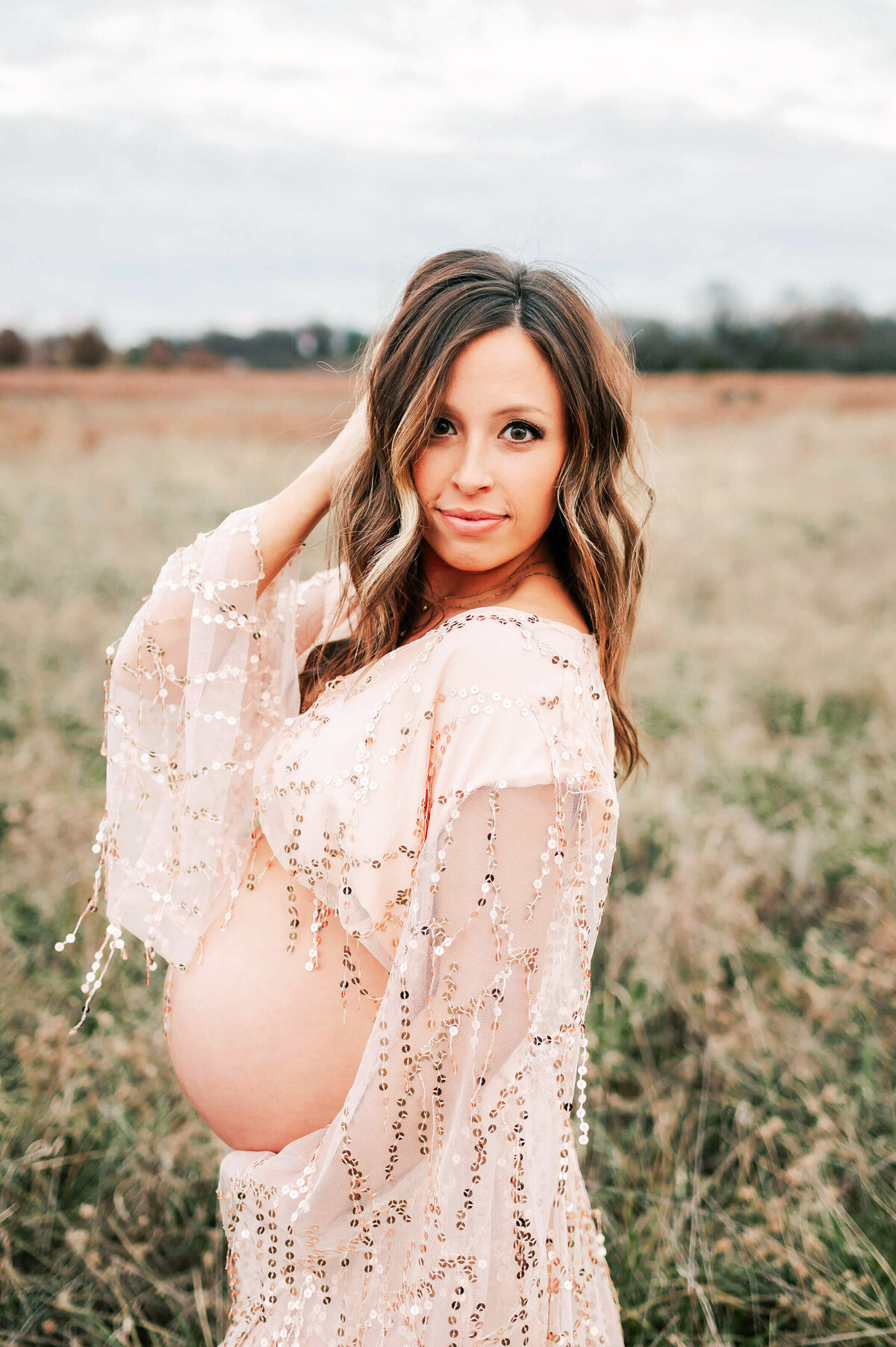 pregnant couple cuddling in field enjoying her maternity photography in Springfield, MO