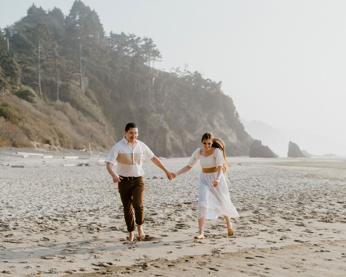 a couple holding hands while walking on the beach