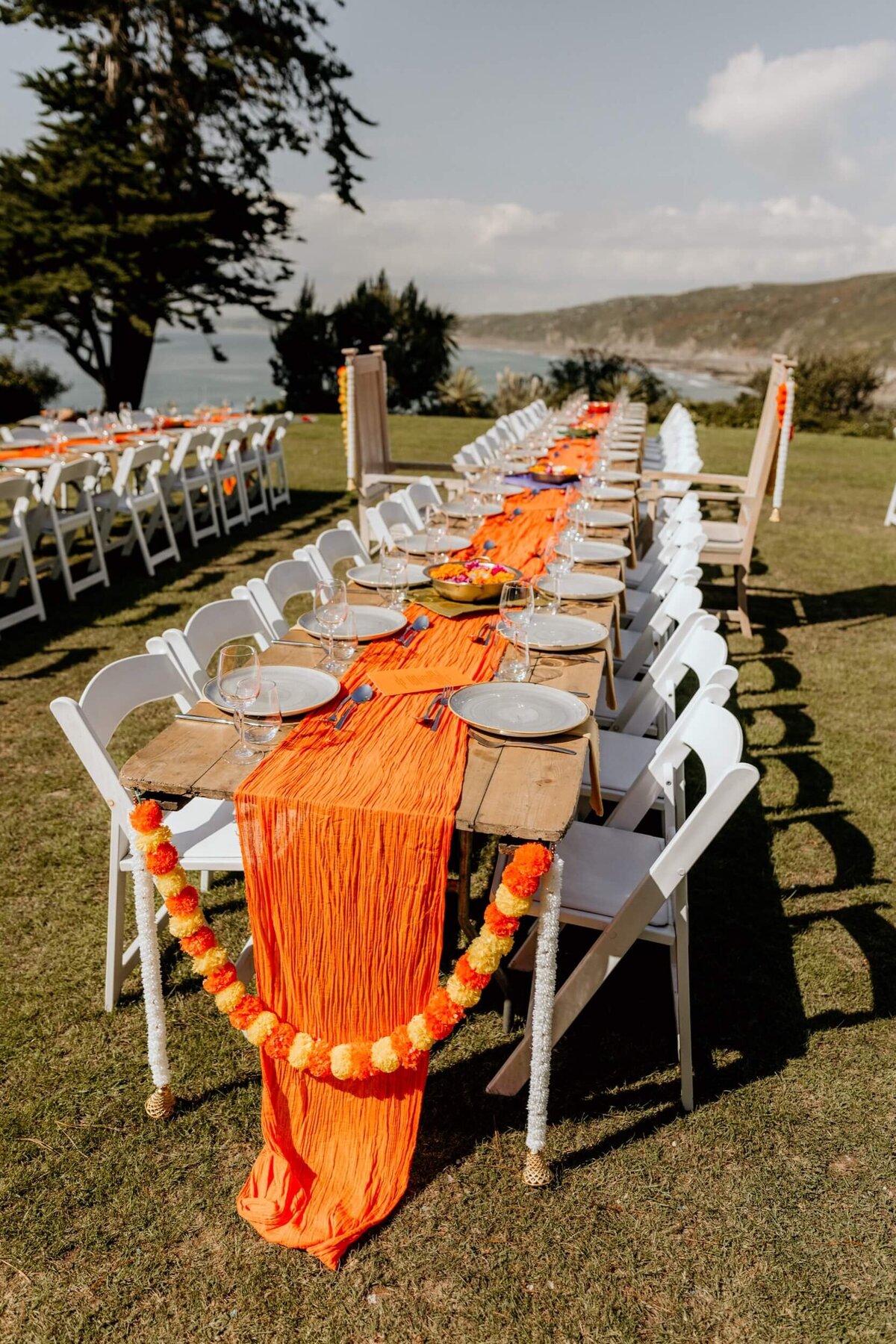 A long table set up with orange and white decorations