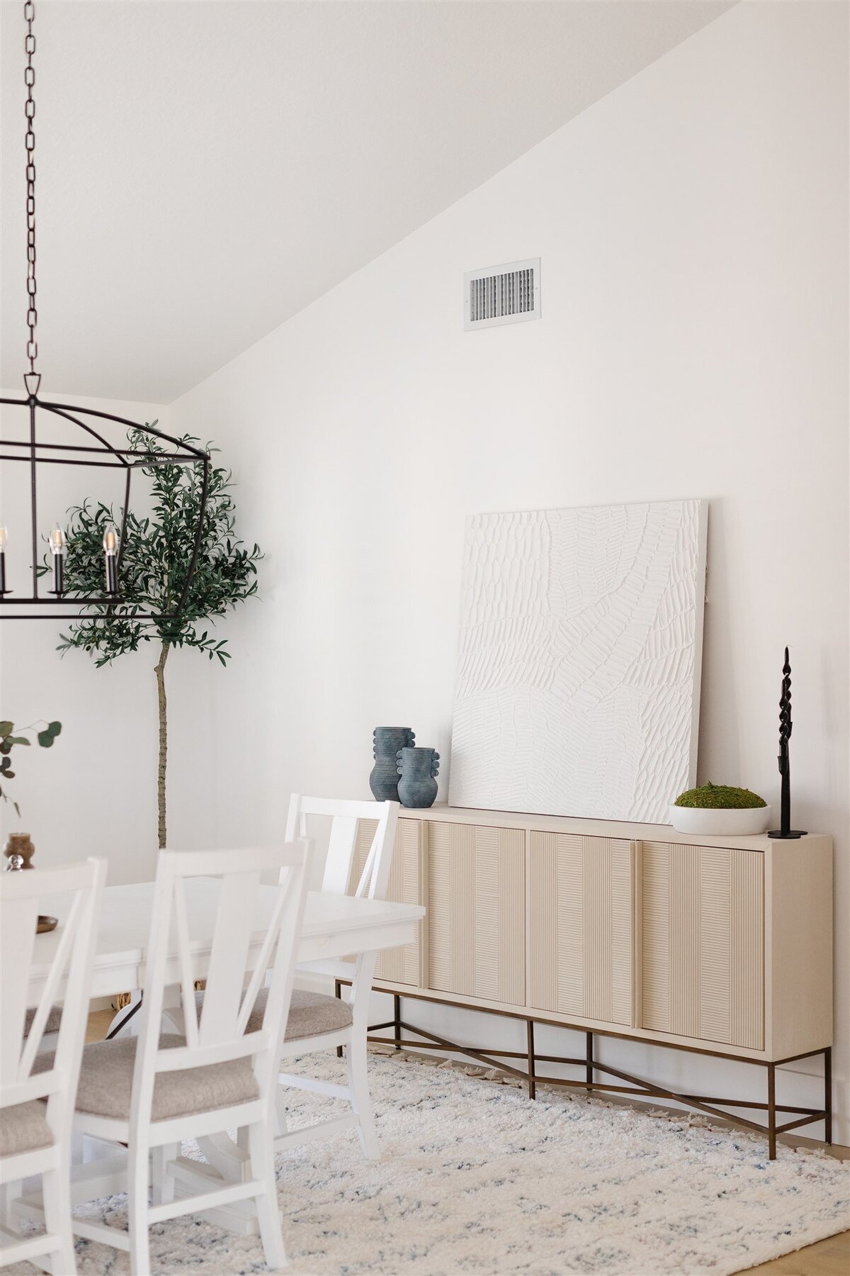 White dining room table and chairs with wooden sideboard