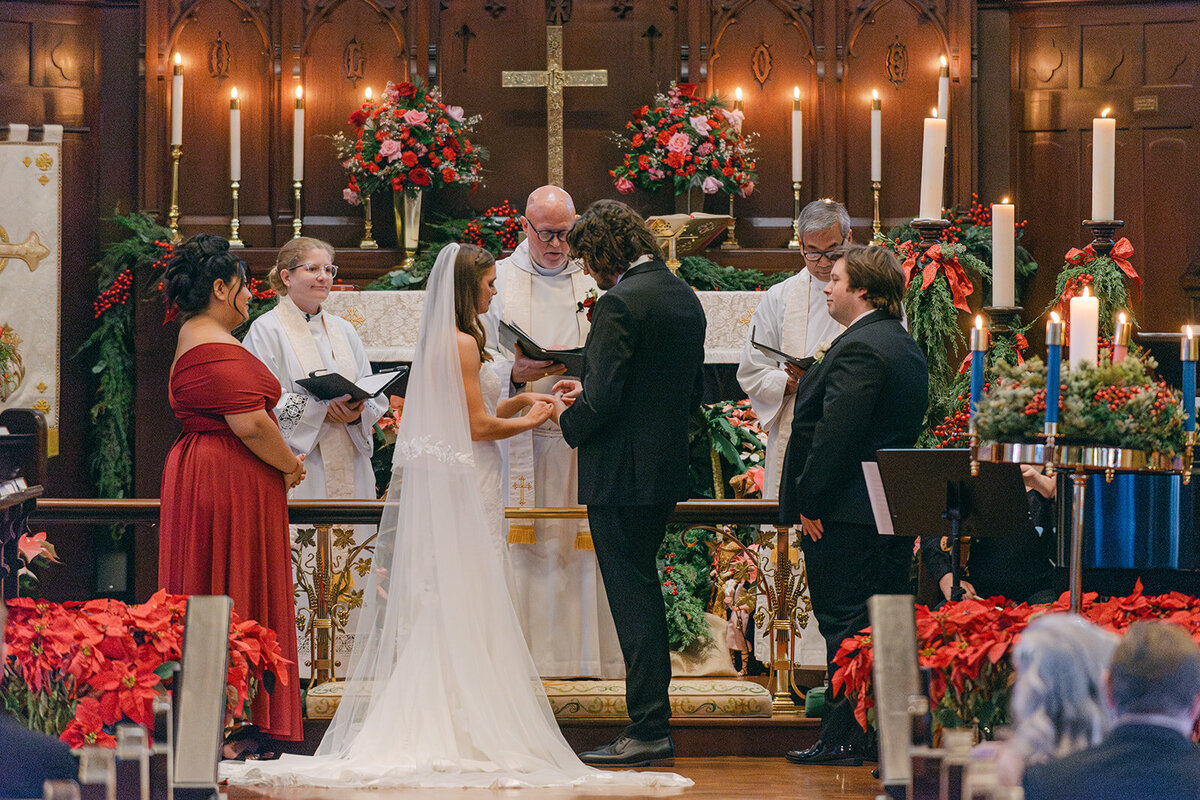 Documentary image of bride and groom exchanging rings at the front of the altar during San Antonio Wedding Ceremony