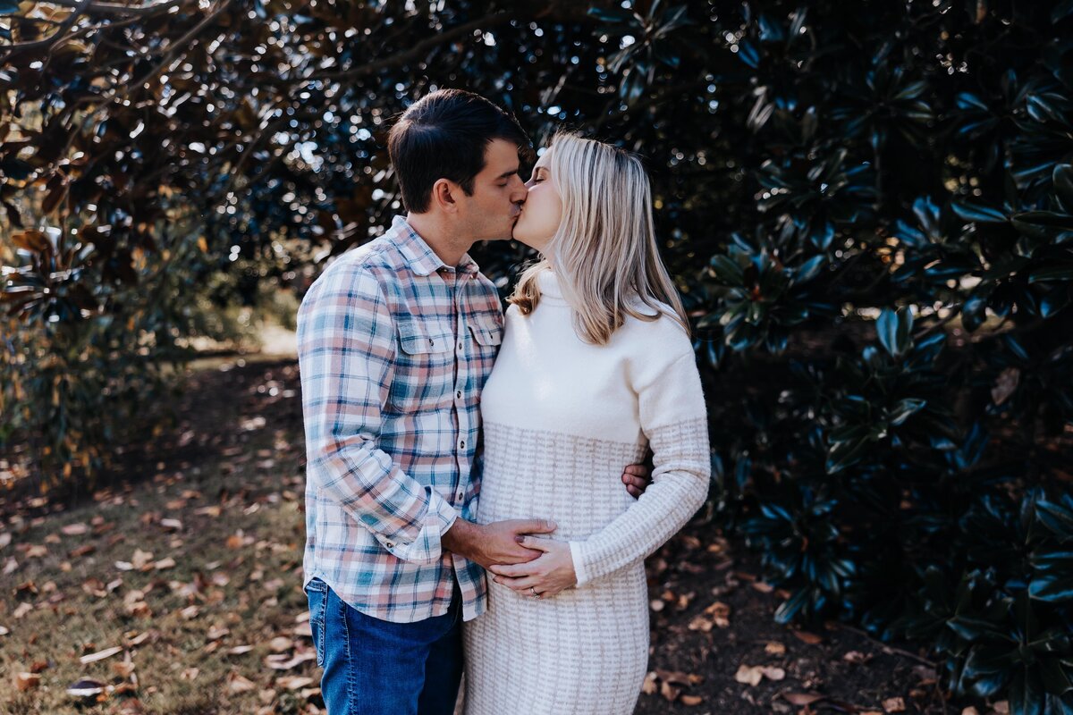 Nashville family photographers capture couple kissing during maternity photos