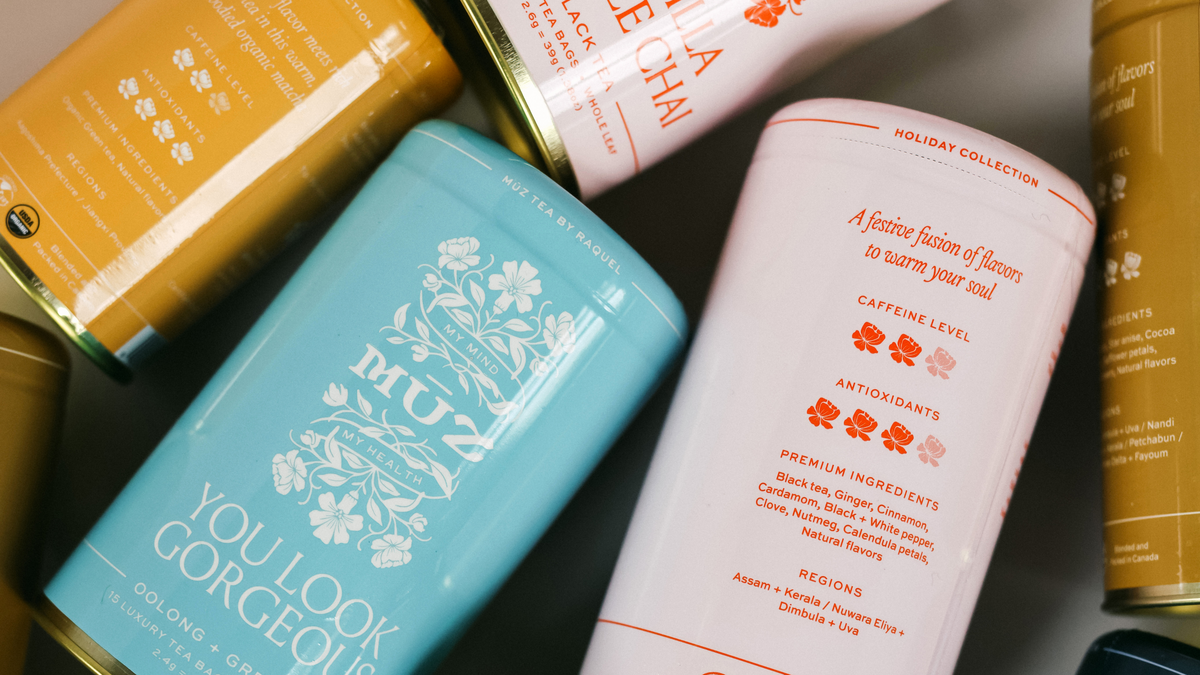 MUZ Tea Cans scattered showing both front facing and back of cans. The front shows the MUZ logo, blend name, and blend type. While the back of the can shows the caffeine level, antioxidant level, ingredient level, and regions of where the ingredients were sourced from. 