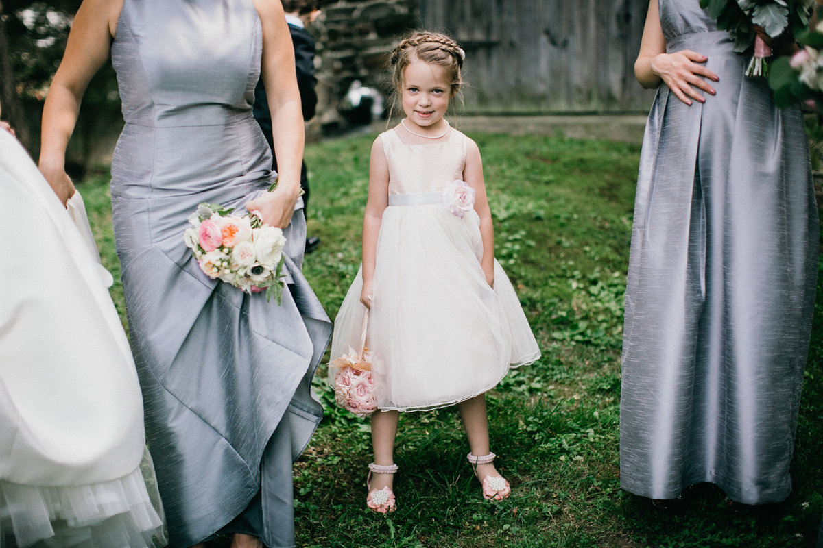 Playful shot of flower girl with the bridesmaids before walking down the aisle at Grace Winery.