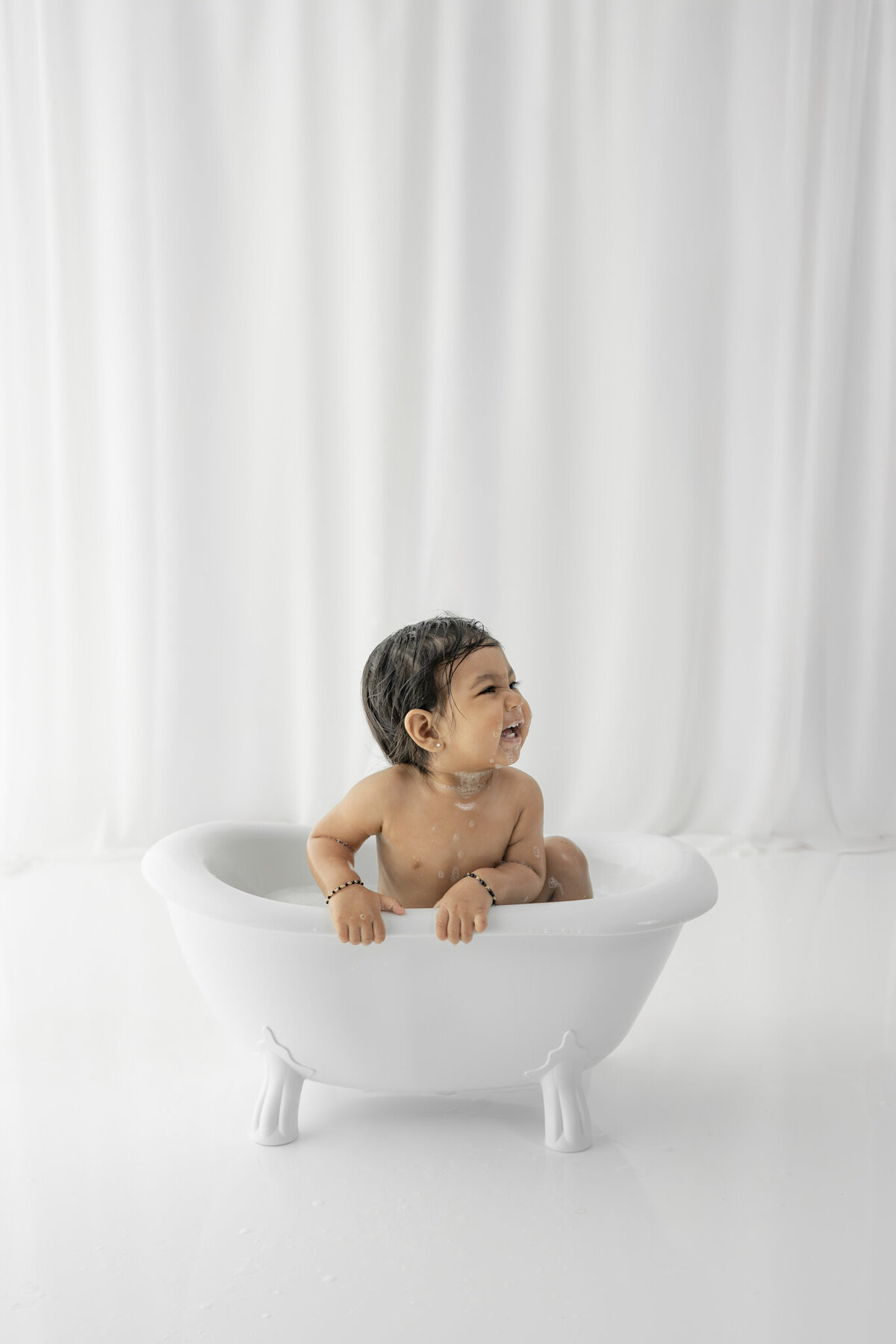 Girl in bubblebath following cake smash session— captured by Alliston and Barrie cake smash photographer.