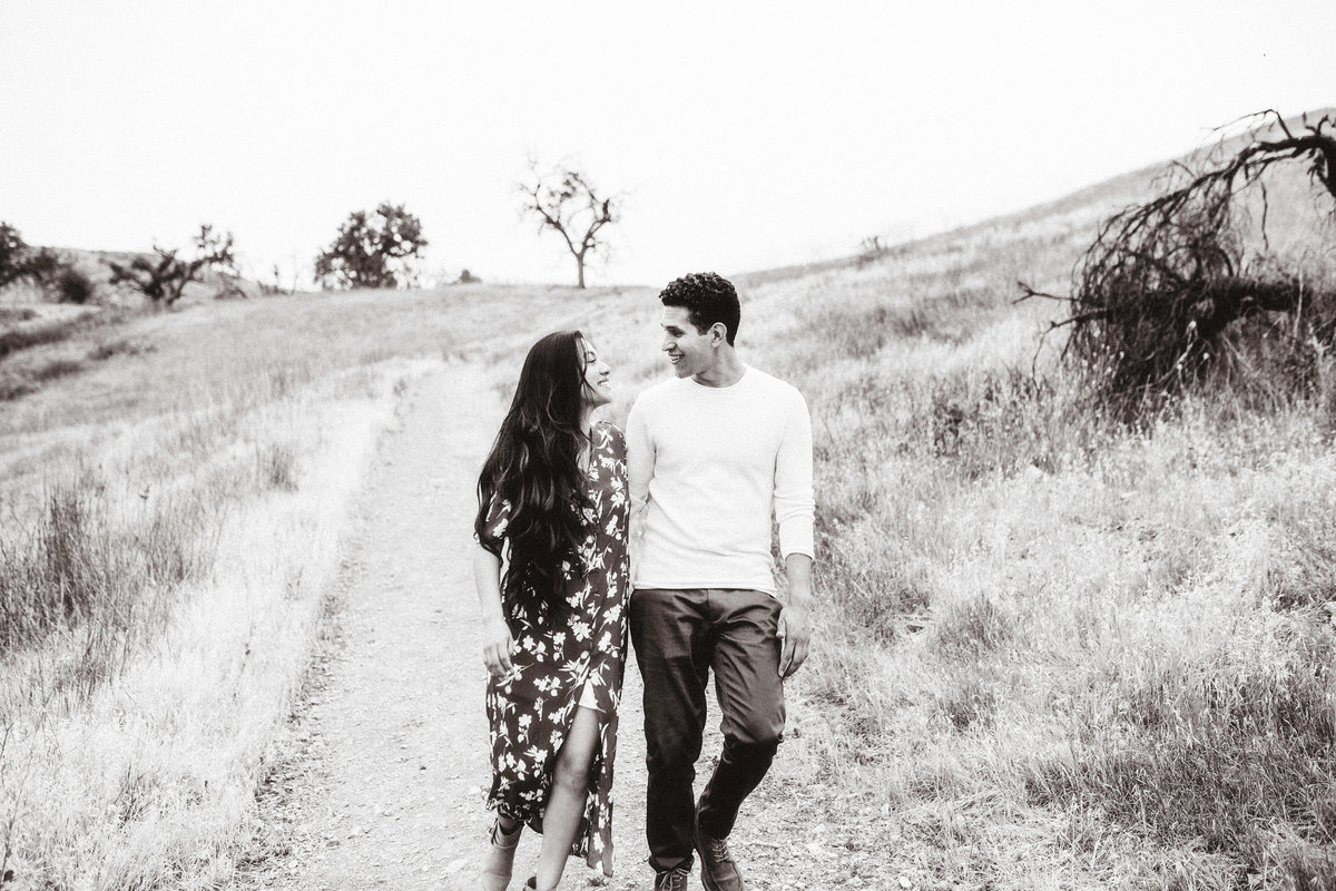 Engagement Photograph Of  Man And Woman Staring at Each Other While Walking Down a Road Los Angeles