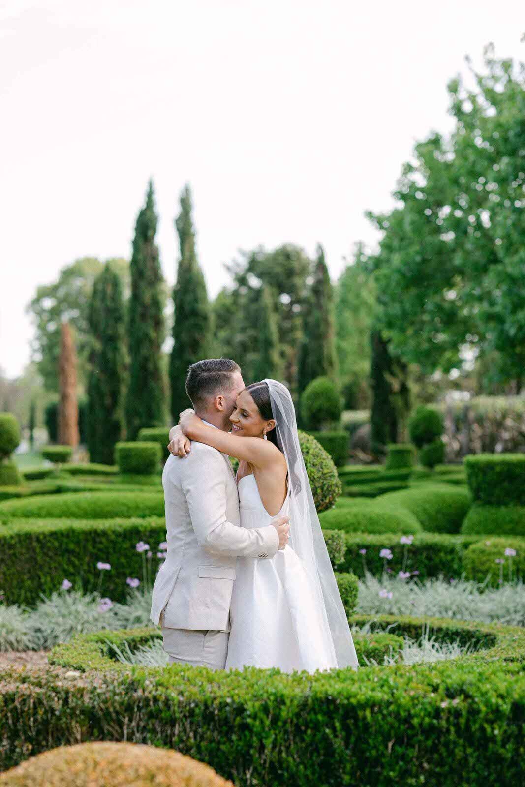 wedding couple's kiss surrounded by the maze in Merribee House Garden