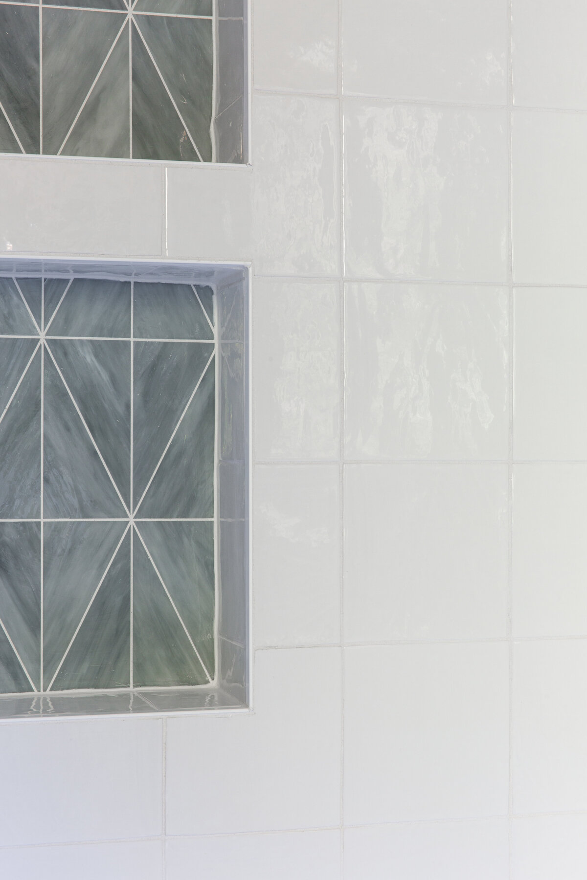 Unique bathroom tile design in Kiawah Island, SC, featuring geometric accents and glossy white finishes.