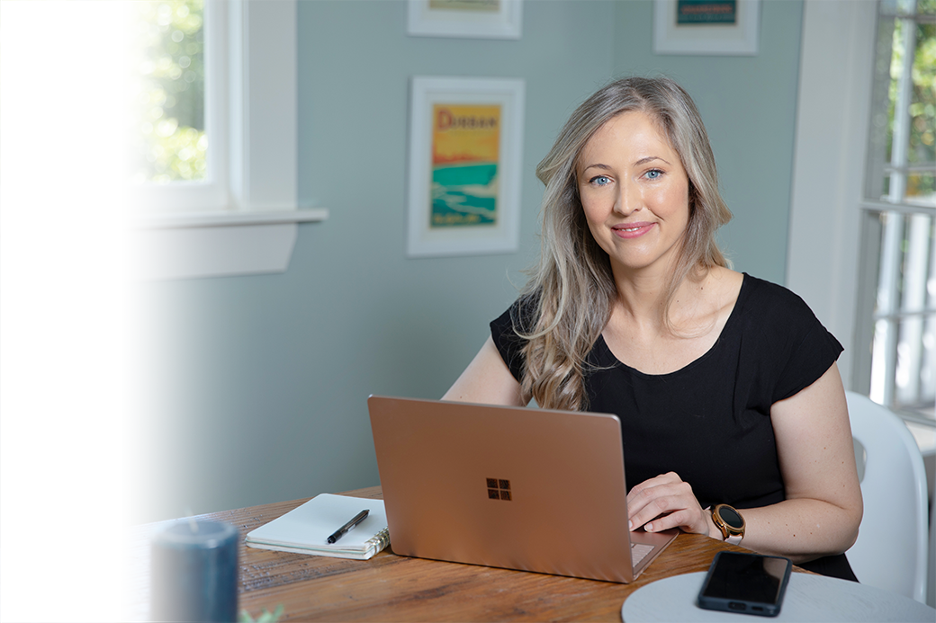 Self employed business woman working on computer  at table.