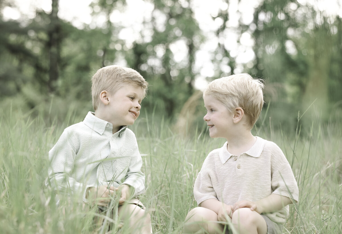two brothers sit and talk in a field
