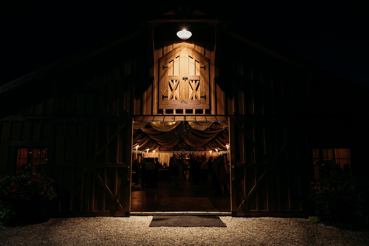 Barn entrance at night with warm lighting inside