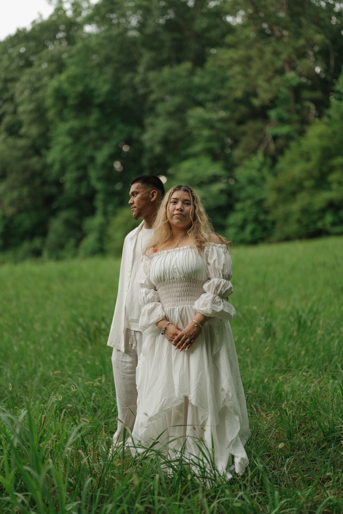 engaged couple posing in a dreamy field
