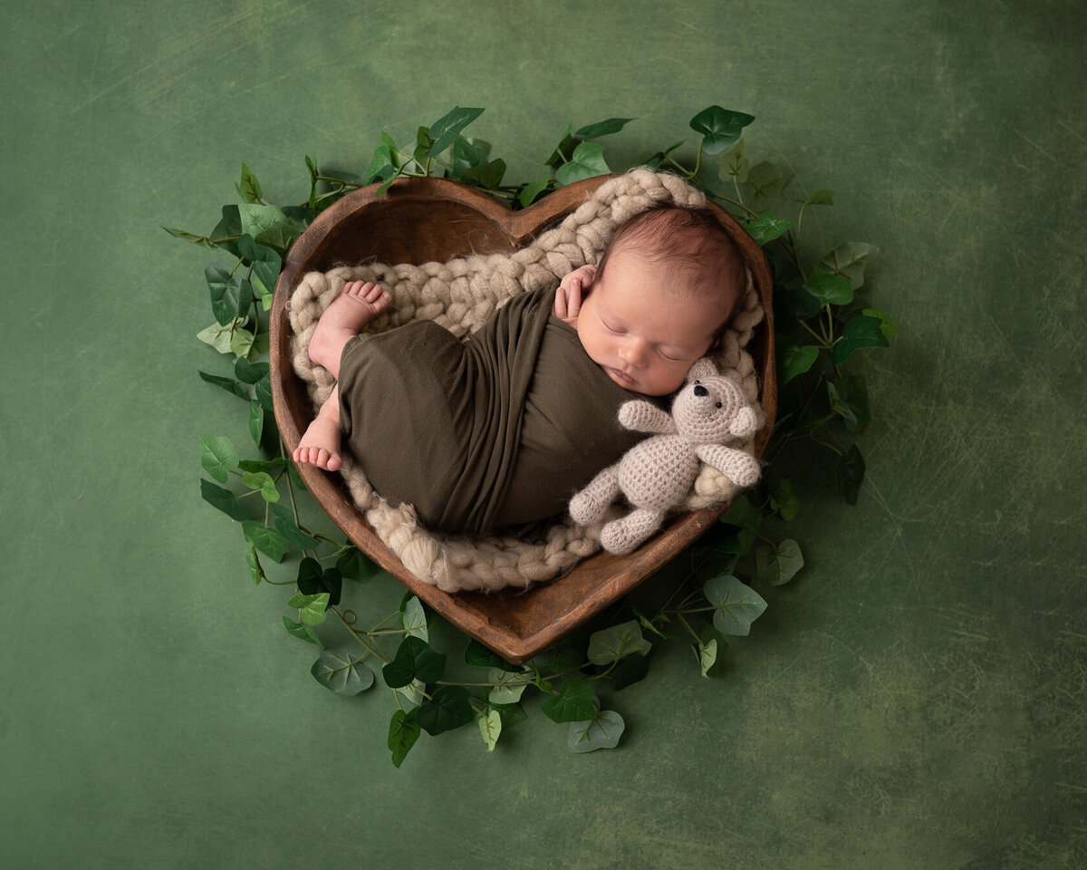 Wrapped Newborn in Green leaves bucket