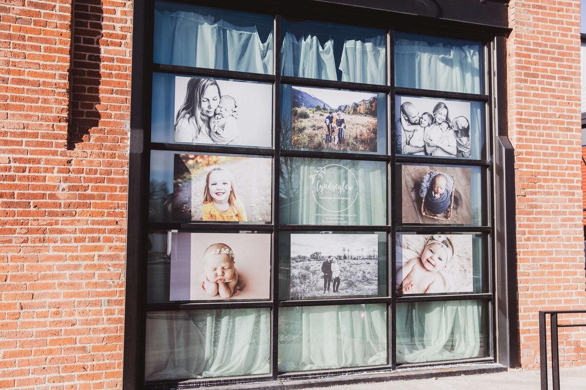 Windows of a Denver area photography studio filling with newborn, family, and milestone photos.