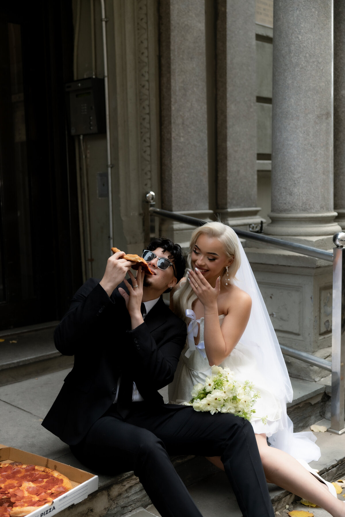 The couple having a playful pizza night in NYC to celebrate their intimate elopement.