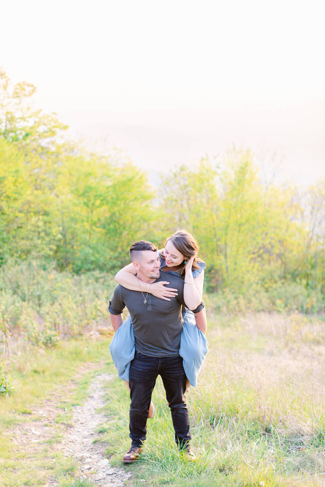 Bride getting a piggyback ride in the mountains during their engagement session in Shenandoah National Park.