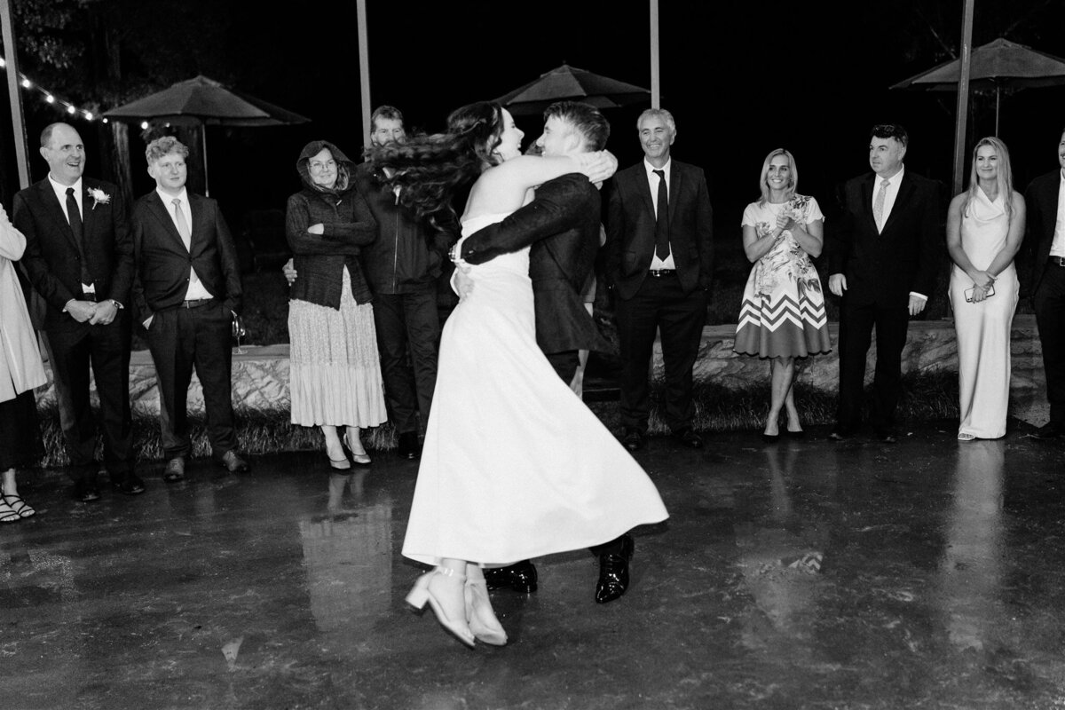 A heartwarming moment captured: a couple swaying together on the dance floor at their wedding reception, enveloped in love and joy.